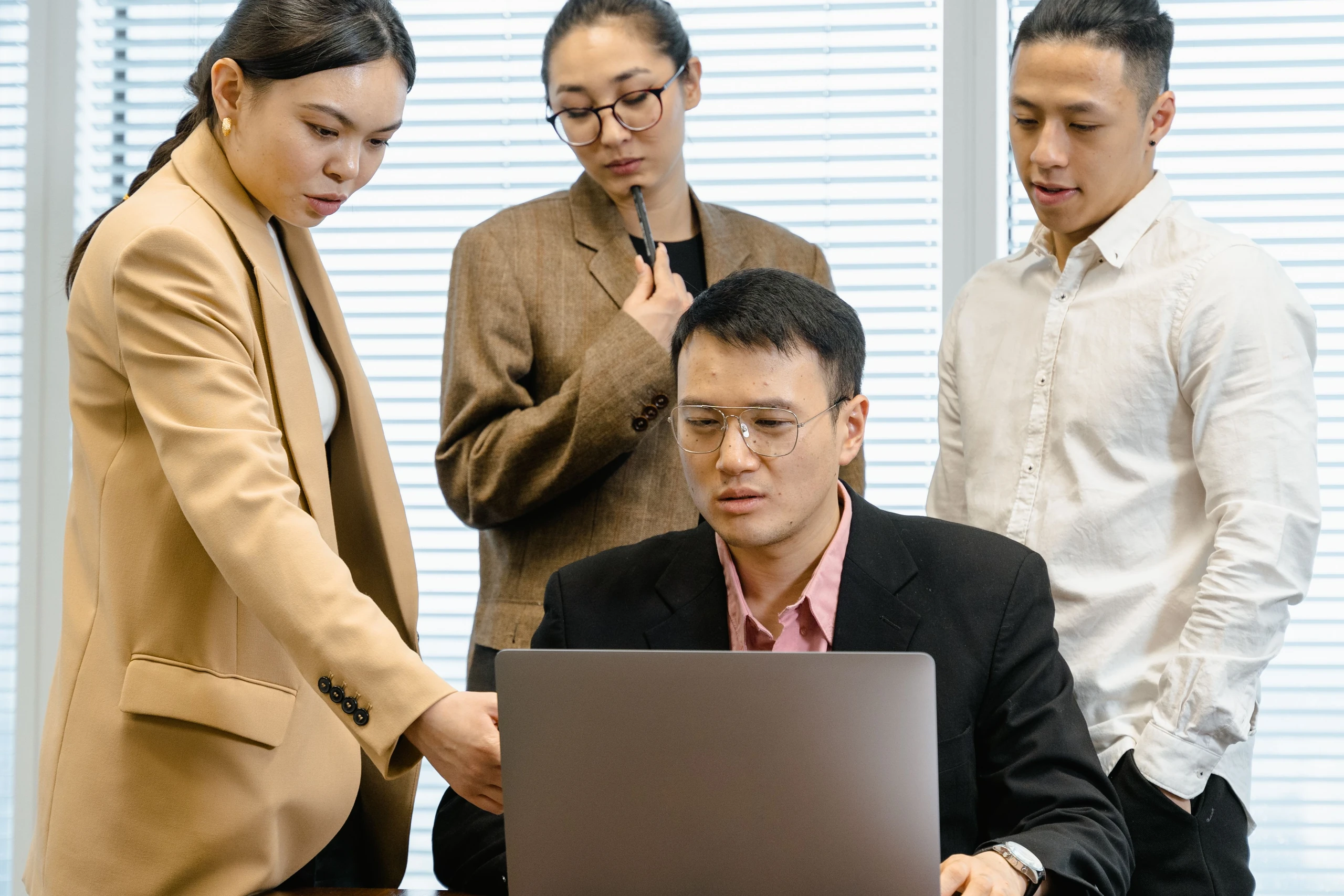 Colleagues discussing their work together around a laptop