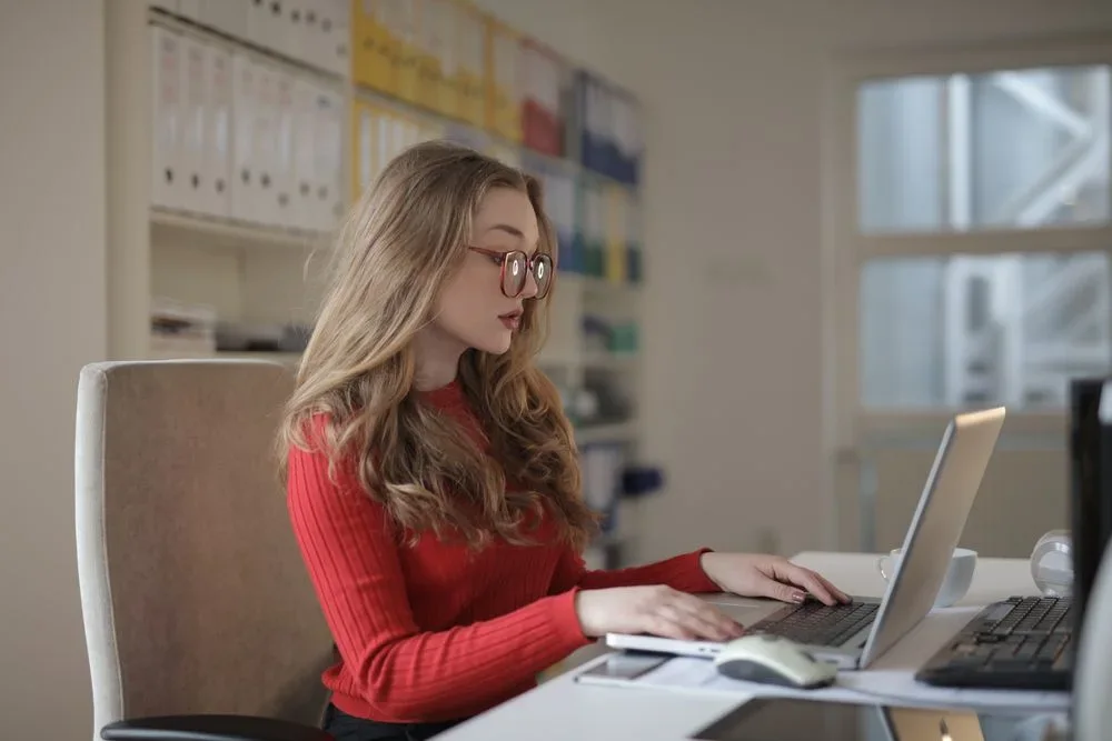 An office worker reviewing records on a laptop
